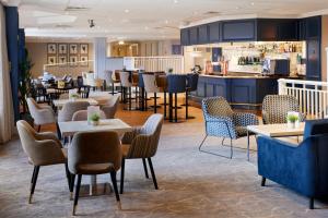 um restaurante com mesas e cadeiras e um bar em Coldra Court Hotel by Celtic Manor em Newport