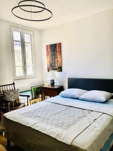 een slaapkamer met een groot bed en een kroonluchter bij Appartement Standing Hôtel Particulier Montpellier in Montpellier