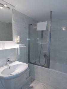 a white bathroom with a shower and a sink at Hotel Goldener Stern in Sankt Ingbert