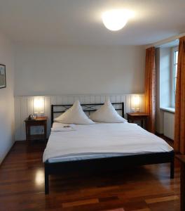 a bedroom with a large white bed with two pillows at Hotel Goldener Stern in Sankt Ingbert