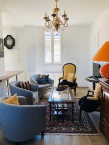 a living room with chairs and a chandelier at Appartement Standing Hôtel Particulier Montpellier in Montpellier