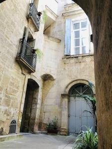 een oud stenen gebouw met een grote deur en ramen bij Appartement Standing Hôtel Particulier Montpellier in Montpellier