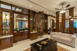 a living room with a couch and a table at StayVista at Dhauladhar House - Aesthetic 4 BHK Villa in Kangra in Dharamshala