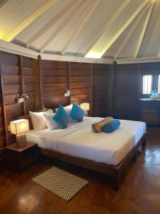 a bedroom with a large bed with blue pillows at Rockside Cabanas Hotel in Unawatuna