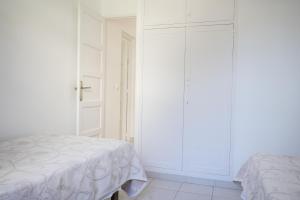 a white bedroom with a bed and a closet at Apartamentos Playa Calan Blanes in Cala en Blanes
