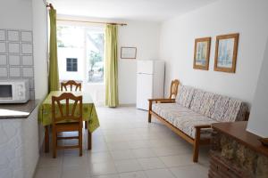 uma sala de estar com um sofá e uma mesa em Apartamentos Playa Calan Blanes em Cala en Blanes