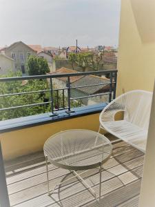 two chairs and a table on a balcony at Appartement hyper centre, plage à pieds, 2 chambres, 4 personnes in Châtelaillon-Plage +4 photos