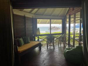 a living room with a couch and a view of the ocean at Rockside Cabanas Hotel in Unawatuna