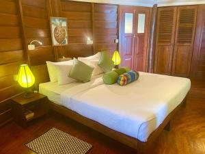 a bedroom with a large white bed with two lamps at Rockside Cabanas Hotel in Unawatuna