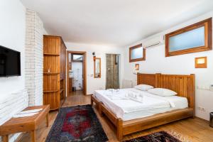 a bedroom with a large bed and a tv at Ephesus Lodge in Kirazli
