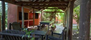 a covered patio with a table and chairs and a table and benches at Casa Roja in Playa Verde