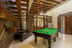 a room with a pool table and a staircase at StayVista at Dhauladhar House - Luxurious Chateau in Kangra in Dharamshala