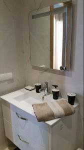 een badkamer met een witte wastafel en een spiegel bij Hivernage Founty in Agadir