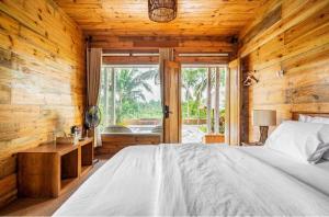 a bedroom with a bed and a wooden wall at Peraja Bungalows Loyok in Sangyang