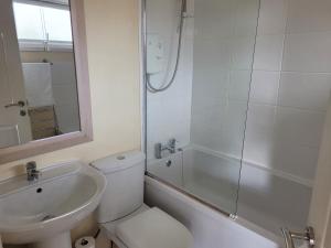 a bathroom with a toilet and a sink and a shower at RentUnique Central Caledonian house cosy home in Crawley