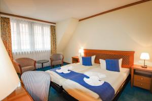 um quarto de hotel com uma cama grande com lençóis azuis e brancos em Gasthaus Zum Schwan em Oschatz