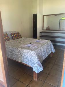 a bedroom with a bed with a table and a mirror at Pousada Princesa do Mar in Tamandaré