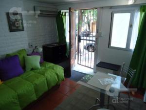 sala de estar con sofá verde y mesa en Studio en PH La casita de Pablo en Buenos Aires