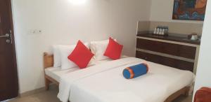 a bedroom with two beds with red and blue pillows at Rockside Cabanas Hotel in Unawatuna