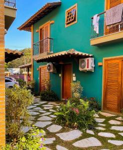 une maison bleue avec une passerelle devant elle dans l'établissement Recanto das Tiribas, à Ilhabela