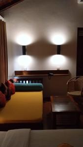 - un salon avec un canapé et deux lumières sur le mur dans l'établissement Rockside Cabanas Hotel, à Unawatuna