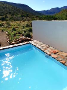 - une piscine avec vue sur la montagne dans l'établissement Ironstone Cottage, à Graaff-Reinet