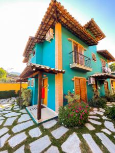 Casa azul y amarilla con balcón y flores en Recanto das Tiribas en Ilhabela