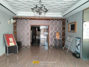 a living room with a chandelier and a hallway at Ashoka Hotel By WB Inn in Alwar