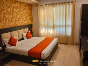 una camera da letto con un letto con cuscini arancioni e arancioni di Ashoka Hotel By WB Inn a Alwar