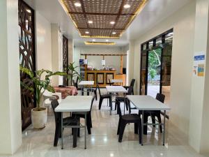 ein Restaurant mit Tischen und Stühlen in einem Zimmer in der Unterkunft TEZA Resort in Bantayan