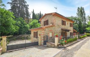 een stenen huis met een poort ervoor bij Cozy Home In Monte San Savino With Wifi in Monte San Savino