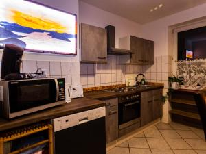 Il comprend une cuisine équipée d'un four micro-ondes et une télévision murale. dans l'établissement #121 Große, gemütliche Wohnung in Remscheid-City, à Remscheid