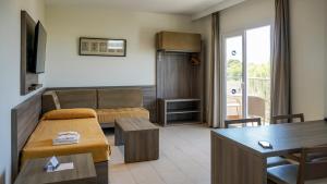 een woonkamer met een bank en een tafel bij Cabot Tres Torres Apartamentos in Playa de Palma
