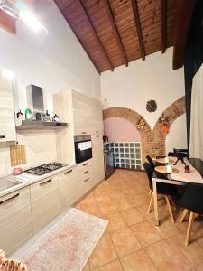 a kitchen with a table and a dining room at Loft Dei Lupi 260m dal Duomo FreeParking in Cremona