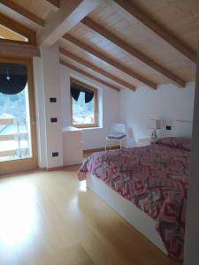 1 dormitorio con cama y ventana grande en Appartamento Mary - Casa Green - Dog friendly, box auto, en Cogolo