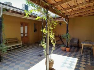 un patio con una mesa, un banco y un árbol en Casa Vieytes en San Antonio de Areco