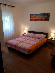 a bedroom with a bed with two pillows on it at Apartman Laura in Kaštela