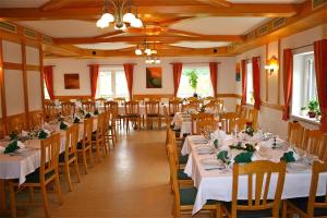 un comedor con mesas y sillas blancas en Gasthaus - Gästehaus Schusterbauer en Rein