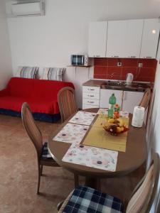 a kitchen with a table and chairs and a table and a couch at Apartman Laura in Kaštela