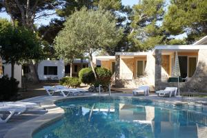 a villa with a swimming pool and a house at Apartamentos Playa Calan Blanes in Cala en Blanes