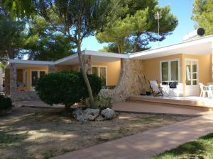 a house with a tree in front of it at Apartamentos Playa Calan Blanes in Cala en Blanes