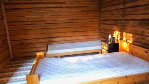 1 dormitorio con 1 cama en una cabaña de madera en Little Forest House "Our Little Farm" en Ekshärad