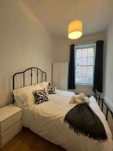 a bedroom with a large white bed with a window at Stay in the heart of Soho in London