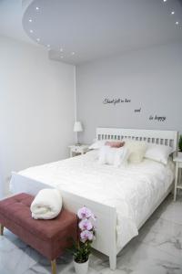 a white bedroom with a large bed with a sign on the wall at B&B Carpe Diem in Castel Gandolfo