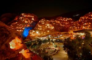 een uitzicht op een resort 's nachts met verlichting bij Little Petra Bedouin Camp in Al Ḩayy