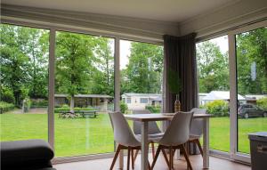 a dining room with a table and chairs and windows at Nice stacaravan In Marienberg With Kitchen in Mariënberg