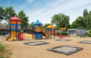 a playground with several play equipment in the sand at Nice stacaravan In Marienberg With Kitchen in Mariënberg