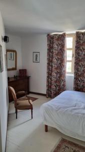 1 dormitorio con 1 cama, 1 silla y 1 ventana en Maison duplex à 5 minutes à pied de la mer, en Binic