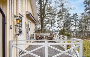 a porch with a table and chairs on a house at Beautiful Home In Hyltebruk With Lake View in Hyltebruk