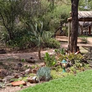 a garden with a fire hydrant in the grass at The Aces - NUDE - SunEden Family Naturist Resort in Pretoria